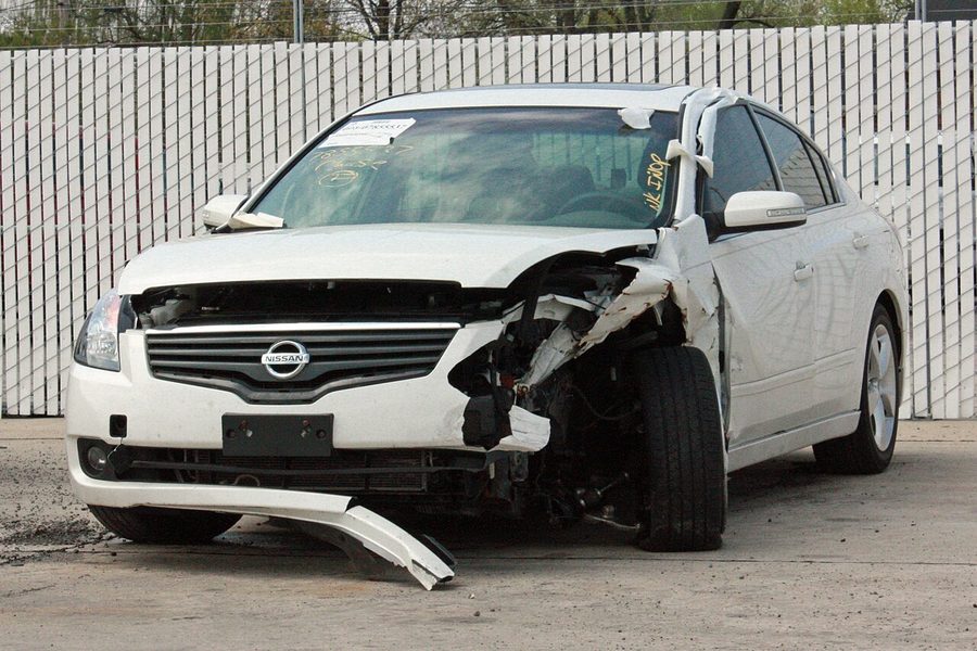 Witte auto met zware schade aan de voorkant